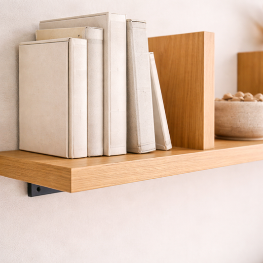 Wooden shelf with books and a bowl on a light background