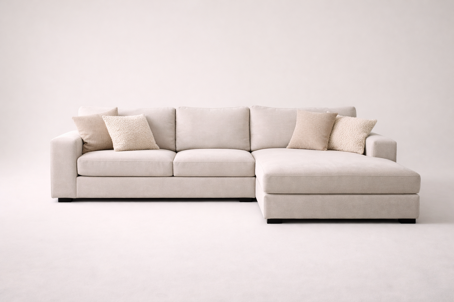Beige sectional sofa with cushions on a white background