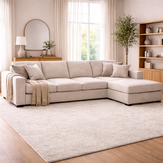 Beige sectional sofa in a living room with a rug and decorative items.