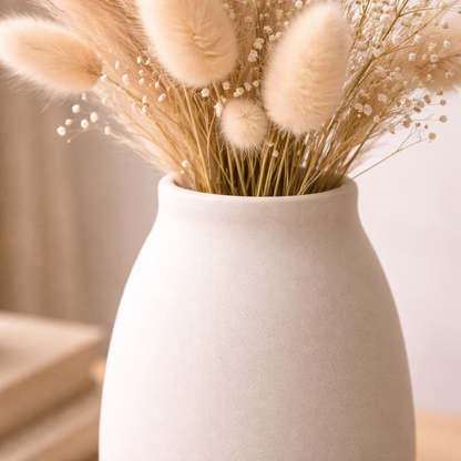 White vase with dried flowers on a blurred background